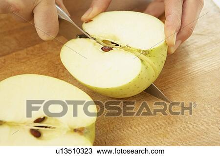 Stock Image - Woman cutting apple, close up. Fotosearch