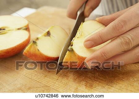 Stock Photograph - Woman cutting apple, close up. Fotosearch
