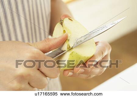 Stock Photography - Woman cutting apple, close up. Fotosearch
