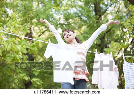 Woman drying laundry, stretching View Large Photo Image Stock Image - Woman drying laundry, stretching. Fotosearch