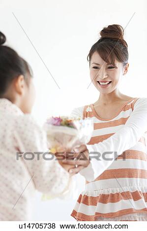 Woman giving flower bouquet to daughter, white background View Large Photo Image Stock Photo - Woman giving flower bouquet to daughter, white background. Fotosearch