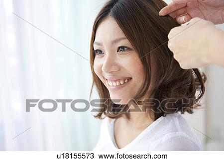 Stock Image - Woman having her hair done. Fotosearch