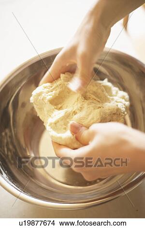 Picture - Woman making bagels, kneading dough, close up, blurred motion. Fotosearch