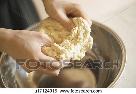 Stock Photography - Woman making bagels, kneading dough, close up. Fotosearch
