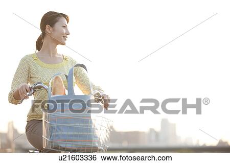 Woman riding bicycle, looking away View Large Photo Image Stock Photograph - Woman riding bicycle, looking away. Fotosearch