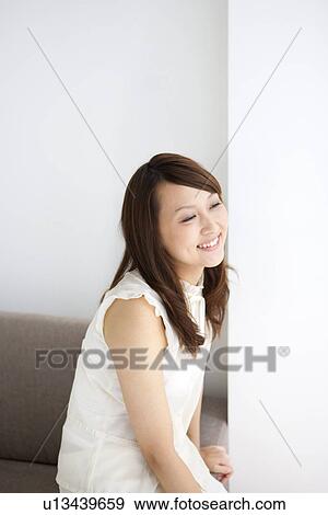 Woman sitting on a sofa View Large Photo Image Stock Photo - Woman sitting on a sofa. Fotosearch