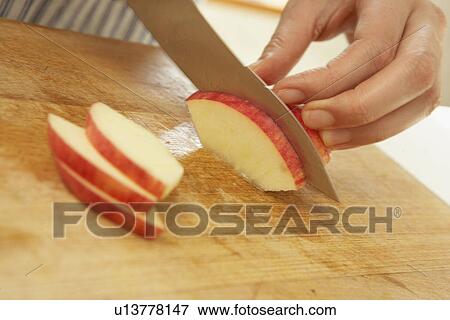 Stock Photo - Woman slicing apple, close up. Fotosearch