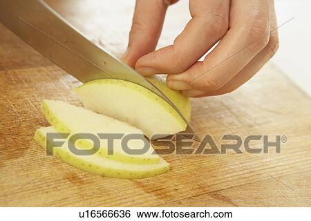 Stock Photograph - Woman slicing apple, close up. Fotosearch