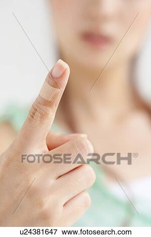 Stock Photo - Woman's finger with bandage, close up, differential focus. Fotosearch