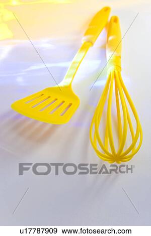 Stock Photo - Yellow whisk and spatula, white background. Fotosearch