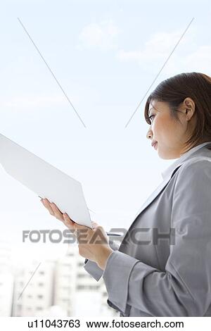 Young businesswoman looking at file View Large Photo Image Stock Image - Young businesswoman looking at file. Fotosearch