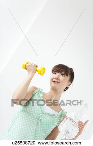 Young woman doing exercise, using dumbbells, white background View Large Photo Image Stock Image - Young woman doing exercise, using dumbbells, white background. Fotosearch