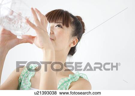 Young woman drinking bottle of water, white background View Large Photo Image Stock Photo - Young woman drinking bottle of water, white background. Fotosearch
