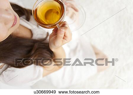 Stock Photo - Young woman holding cup of tea. Fotosearch