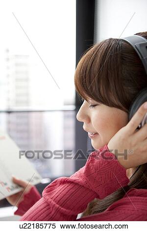 Stock Photography - Young woman listening to music. Fotosearch