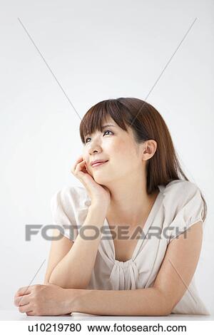 Young woman on white background, resting chin on hand View Large Photo Image Stock Image - Young woman on white background, resting chin on hand. Fotosearch