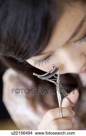 Young woman using eyelash curler, close up View Large Photo Image Picture - Young woman using eyelash curler, close up. Fotosearch