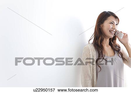 Young woman using mobile phone, white background View Large Photo Image Stock Photo - Young woman using mobile phone, white background. Fotosearch