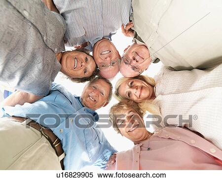 Stock Photography - A group of people huddled together. Fotosearch