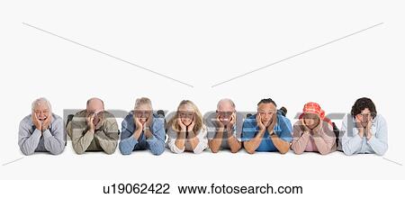 Stock Image - A group of people lying on the floor in a row. Fotosearch