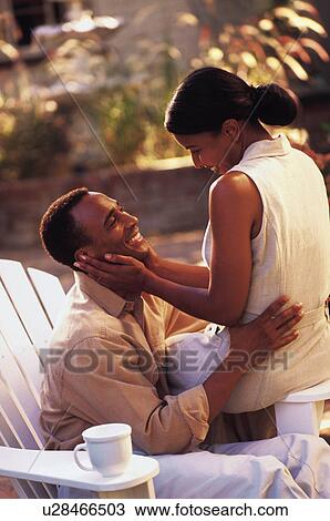 Affectionate couple sitting outdoors together View Large Photo Image Stock Image - Affectionate couple sitting outdoors together. Fotosearch