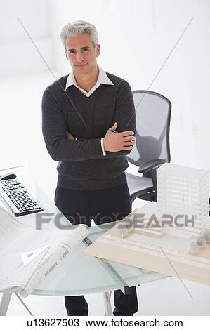 Stock Image - Architect standing behind his desk. Fotosearch