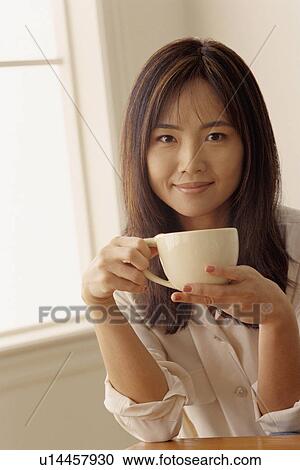 Attractive woman holding a cup of coffee View Large Photo Image Stock Image - Attractive woman holding a cup of coffee. Fotosearch