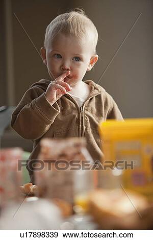 Stock Photo - Baby licking food off fingers. Fotosearch