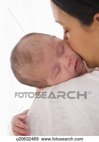 Baby sleeping on mother's shoulder View Large Photo Image Stock Photo - Baby sleeping on mother's shoulder. Fotosearch