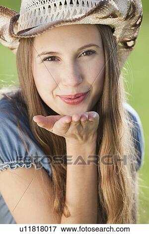 Stock Photo - Beautiful cowgirl blowing a kiss. Fotosearch