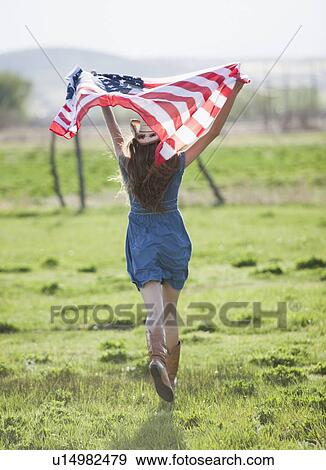 Beautiful cowgirl running with American flag in her arms View Large Photo Image Stock Photo - Beautiful cowgirl running with American flag in her arms. Fotosearch