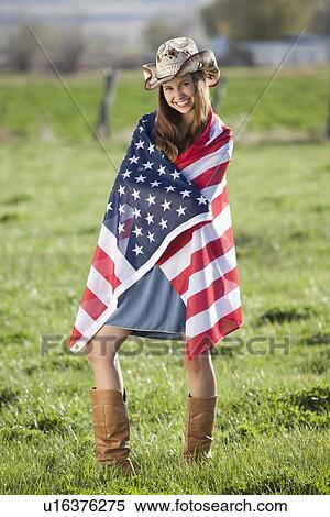 Stock Photography - Beautiful cowgirl wrapped in American flag. Fotosearch