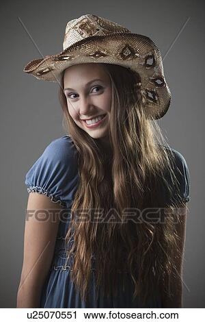 Stock Image - Beautiful long haired cowgirl. Fotosearch