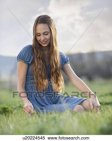 Beautiful long haired woman relaxing on the grass View Large Photo Image Stock Photography - Beautiful long haired woman relaxing on the grass. Fotosearch