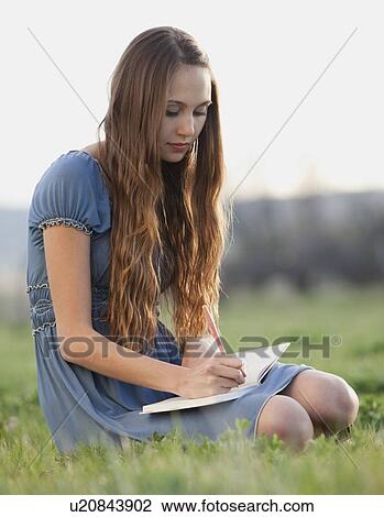Beautiful long haired woman writing in journal View Large Photo Image Stock Image - Beautiful long haired woman writing in journal. Fotosearch