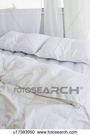 Stock Image - Bed with white linens. Fotosearch