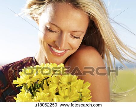 Blond woman holding yellow flowers View Large Photo Image Stock Image - Blond woman holding yellow flowers. Fotosearch