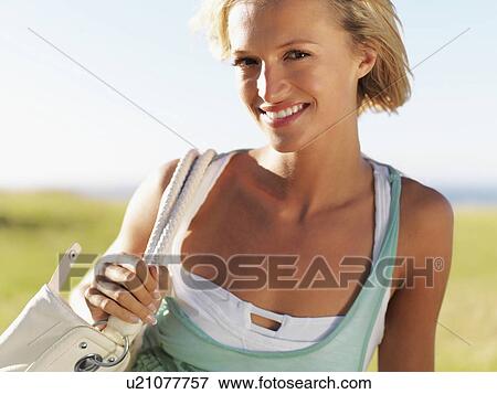 Blond woman sitting on grass in park View Large Photo Image Stock Photo - Blond woman sitting on grass in park. Fotosearch