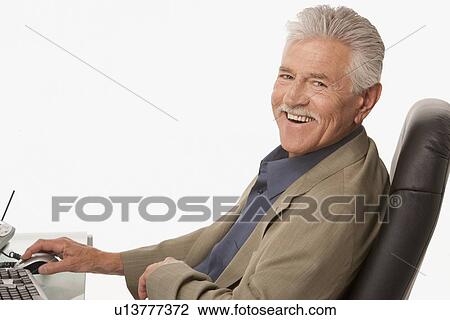 Stock Image - Businessman relaxing at his desk. Fotosearch