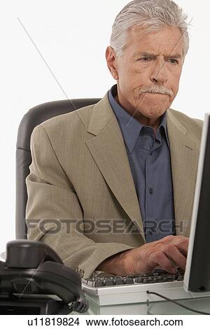 Picture - Businessman working on computer. Fotosearch