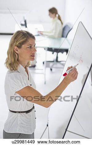 Businesswoman writing on presentation board View Large Photo Image Stock Photo - Businesswoman writing on presentation board. Fotosearch