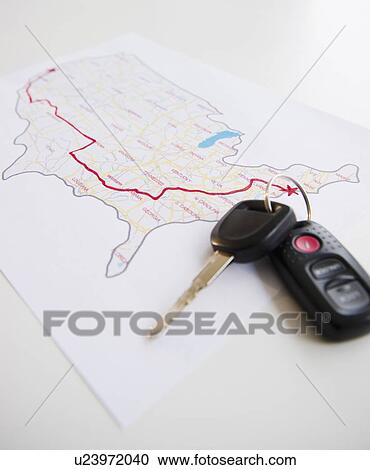 Stock Image - Car keys beside map of planned road trip. Fotosearch