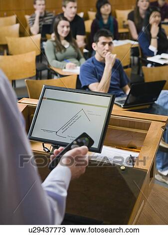 Stock Image - College professor giving lecture in lecture hall. Fotosearch