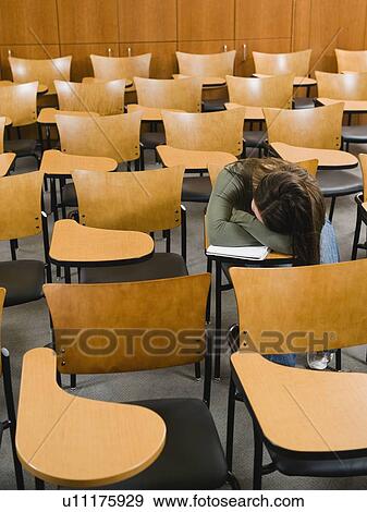 Stock Photo - College student sleeping in empty lecture hall. Fotosearch