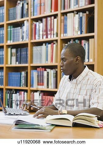 College student working in library View Large Photo Image Stock Photo - College student working in library. Fotosearch