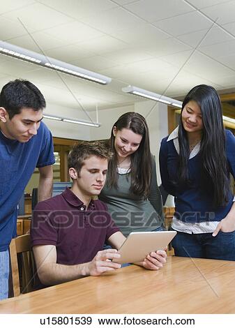 Stock Photo - College students looking at electronic book. Fotosearch