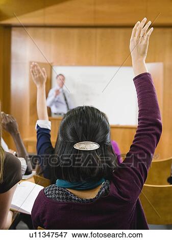 College students raising their hands in lecture hall View Large Photo Image Stock Photo - College students raising their hands in lecture hall. Fotosearch