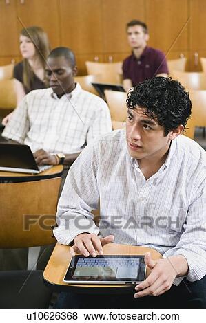 Stock Photo - College students taking notes in lecture hall. Fotosearch