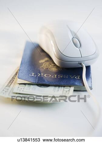 Stock Image - Computer mouse on top of passport and money. Fotosearch