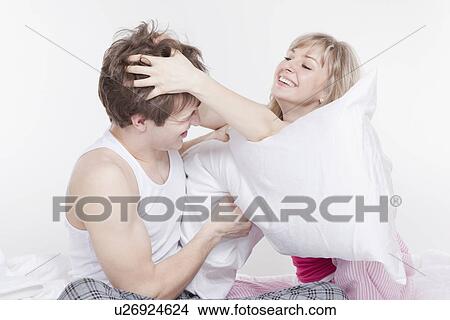 Couple having a pillow fight View Large Photo Image Picture - Couple having a pillow fight. Fotosearch
